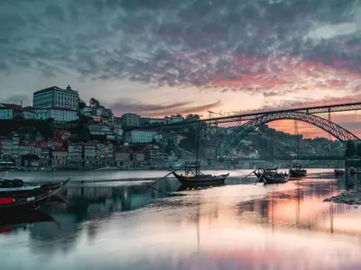 a bridge over a river with boats in the water at Well-maintained air conditioned studio in Porto in Porto