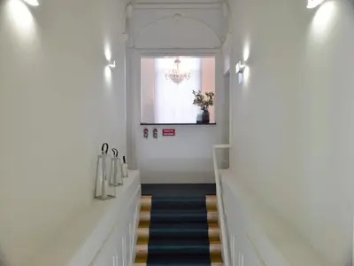 a hallway with stairs with a window and a chandelier at Spacious city apartment with modern amenities in Porto