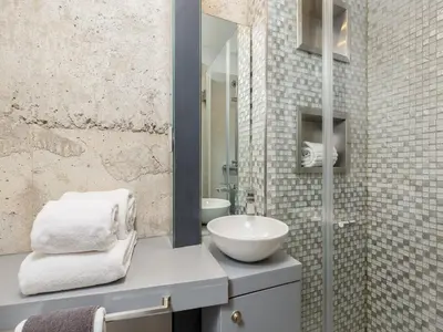 a room with a couch against a stone wall at Charming riverview apartment in Porto in Porto