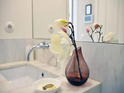 a vase with flowers sitting on a counter in a bathroom at Beautiful apartment in Oporto in Porto