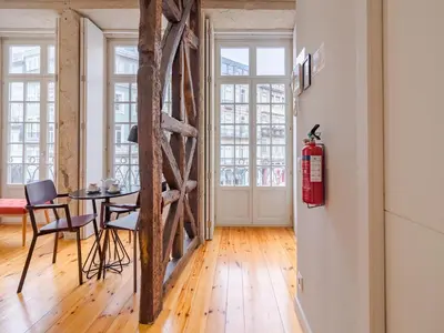 a living room with a table and some wood floors at Charming studio in the heart of Porto in Porto