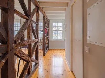 a room with a wooden floor and a wall with a wooden staircase at Comfortable apartment in Oporto in Porto