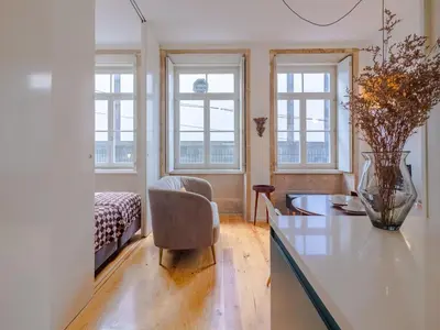 a living room with a vase on a glass table at Stylish Porto studio with city views in Porto