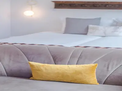 a yellow pillow sitting on a couch next to two beds at Stylish Porto studio with city views in Porto