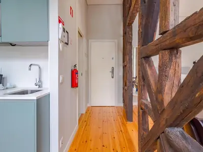 a kitchen with a wooden door and a wooden floor at City-center apartment with modern comforts in Porto