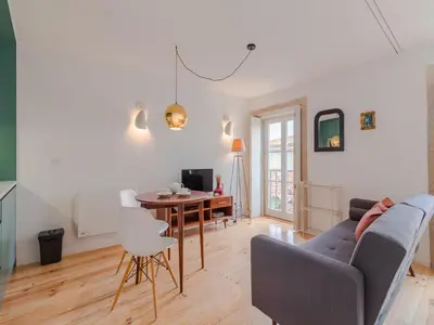 a living room with a couch and a table at Charming studio, ideal for smaller groups in Porto