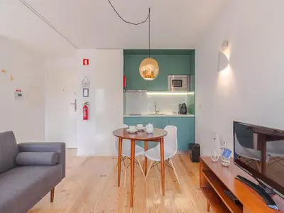 a living room with a table and a couch at Charming studio, ideal for smaller groups in Porto