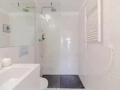 a white bathroom with a shower and a toilet at Charming studio, ideal for smaller groups in Porto
