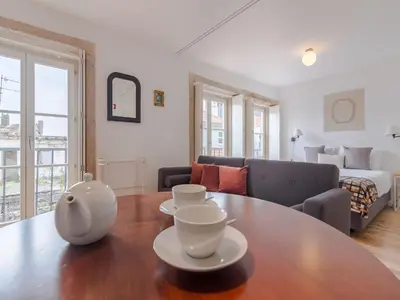 a living room with a table and a couch at Charming studio, ideal for smaller groups in Porto