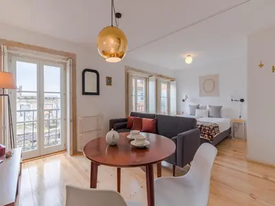 a living room with a couch and a table at Charming studio, ideal for smaller groups in Porto