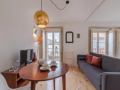 a living room with a couch and a table at Charming studio, ideal for smaller groups in Porto
