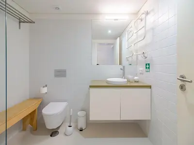 a white bathroom with a toilet and a sink at Charming apartment with convenient city access in Porto