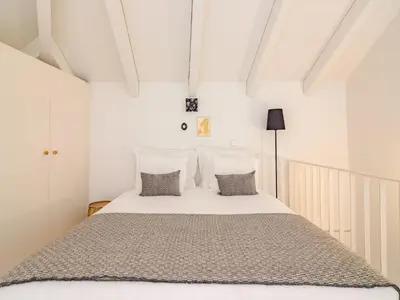 a bedroom with a large white bed with pillows at Charming apartment with convenient city access in Porto