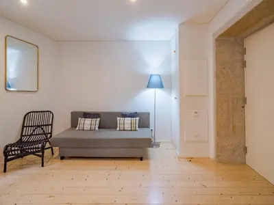 a living room with a couch and a chair at Charming apartment with convenient city access in Porto