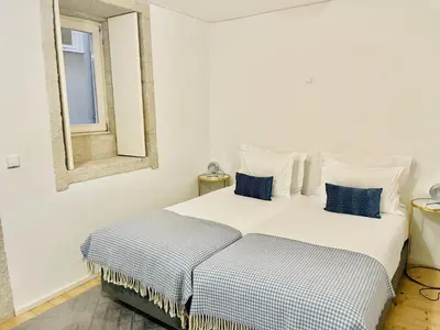 two beds in a white room with a mirror at Charming studio, ideal for smaller groups in Porto