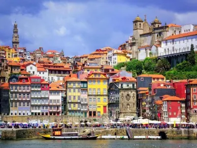 a group of colorful buildings on a hill next to the water at Charming studio, ideal for smaller groups in Porto