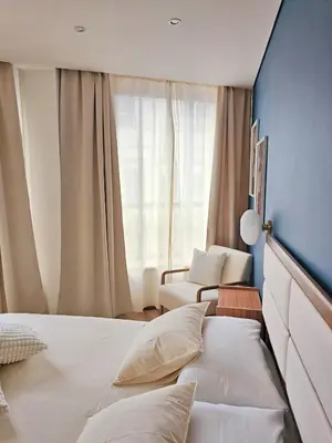 a bedroom with a bed and a chair and a window at Ninho Santa Catarina in Porto