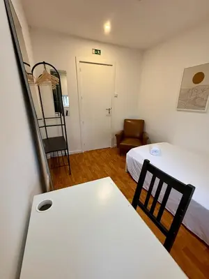 a room with a bed and a table and a ladder at GuestHouse Bragas Porto Center in Porto