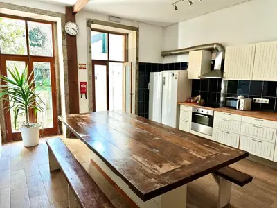 a kitchen with a wooden table and a wooden bench at GuestHouse Bragas Porto Center in Porto