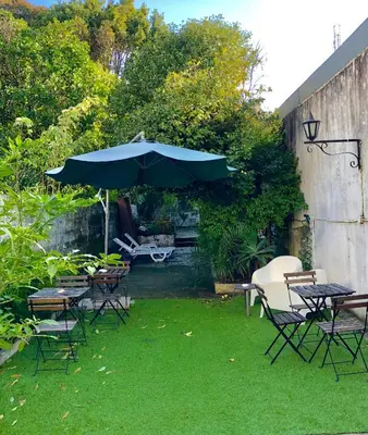 a patio with a table and chairs and an umbrella at GuestHouse Bragas Porto Center in Porto