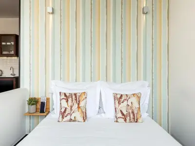 a bed with white sheets and pillows in a room at Apartment near Praia da Luz beach in Porto