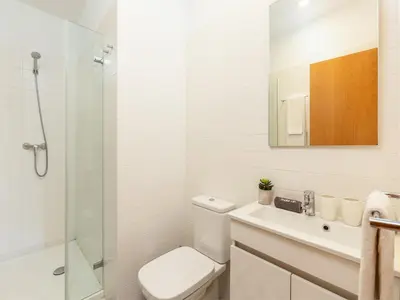 a bathroom with a toilet and a sink and a shower at Stylish City-Center Retreat in Porto