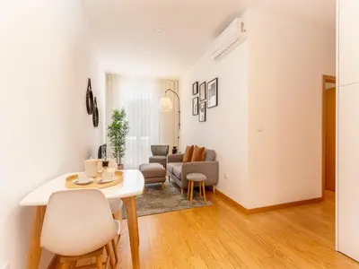 a kitchen and living room with a table and chairs at Stylish City-Center Retreat in Porto
