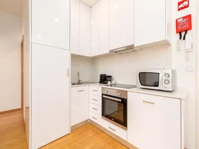 a kitchen with white cabinets and a microwave at Stylish City-Center Retreat in Porto