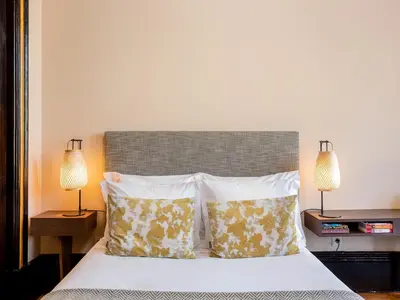 a bedroom with a bed with pillows and two lamps at Chic Porto Studio Cozy & Central Escape in Porto