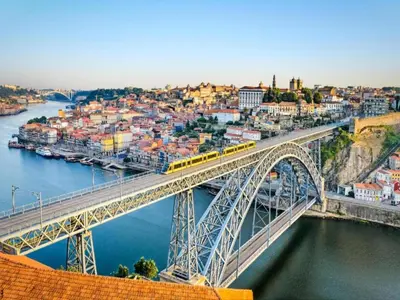 a bridge over a river with a train on it at Beautiful apartment near Oporto city centre in Porto