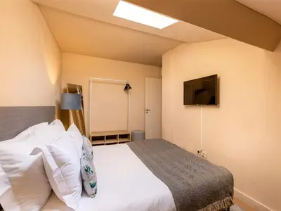 a bedroom with a bed and a flat screen tv at Duplex 2 Bedroom Apt for 3 in Bolhão Market in Porto