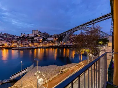a view of a bridge over a river at night at Modern & Cozy apartment, by the beach in Vila Nova de Gaia