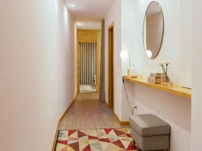 a hallway with a mirror and a stool at Modern & Cozy apartment, by the beach in Vila Nova de Gaia
