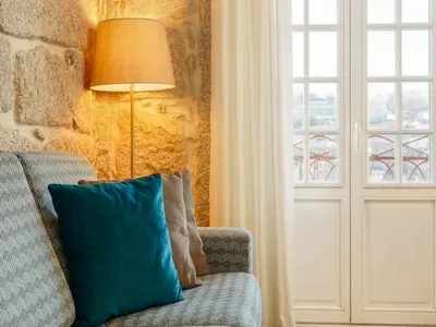 a blue pillow on a chair next to a window at River-View Retreat in Porto in Porto