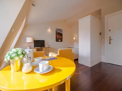 a yellow table in a living room with a yellow room at City-center apartment with modern comforts in Porto