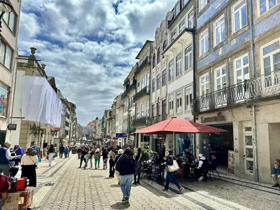 a group of people walking down a city street at Cozy Porto studio with balcony in Porto