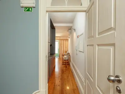 a hallway with a door leading to a kitchen at Cozy Porto studio with balcony in Porto
