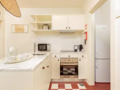 a kitchen with white cabinets and a refrigerator at Apartment in Porto with balcony in Porto