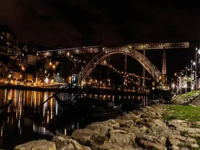 a bridge over a body of water at night at Modern and cozy apartment in Porto in Porto