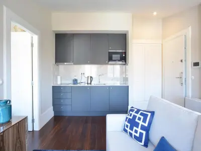 a living room with a white couch and a kitchen at Porto Retreat Comfort & Style in the Heart in Porto