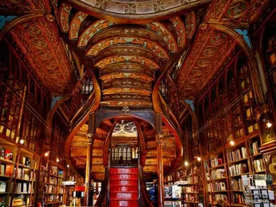 a library with a large ceiling with bookshelves at Porto Retreat Comfort & Style in the Heart in Porto