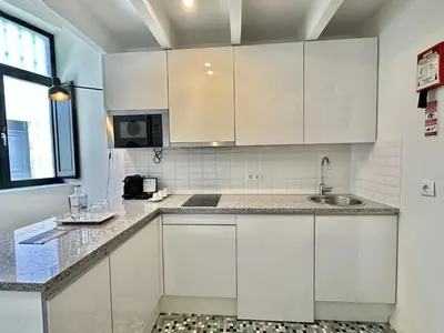 a kitchen with white cabinets and a sink at Charming 2-Bedroom Apartment in Porto in Porto
