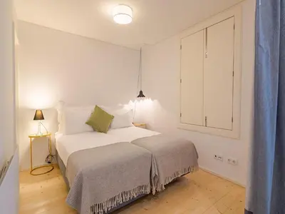 a white bedroom with a bed and a window at Central Porto Comfort Stay in Porto