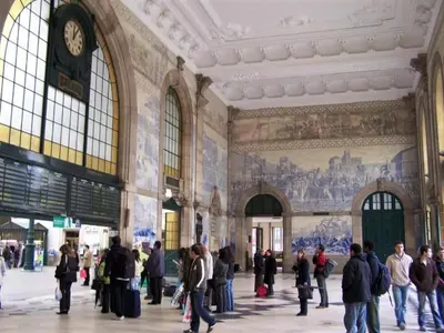 a group of people walking around a building with a clock at Central Porto Comfort Stay in Porto
