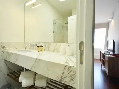 a bathroom with a marble sink and a mirror at Modern apartment in Porto's Vibrant Heart in Porto