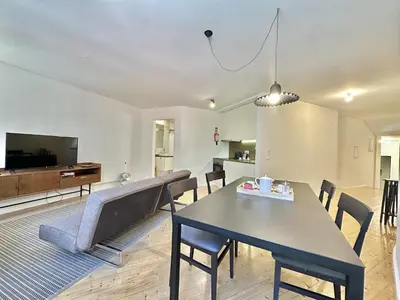 a living room with a table and chairs and a tv at Heart of Porto Cozy Escape in Porto