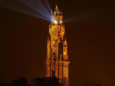 a tall clock tower with a light on top at night at Heart of Porto Cozy Escape in Porto