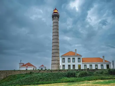 a lighthouse in front of a white building at 1-bedroom beautiful apartment in Oporto in Porto