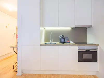 a kitchen with white cabinets and a sink at 1-bedroom beautiful apartment in Oporto in Porto