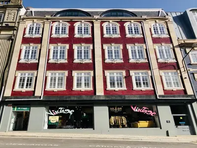 a large building with white windows on a street at Bright and Spacious apartment in Porto in Porto